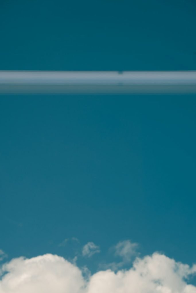 a-plane-flying-through-a-blue-sky-with-white-clouds-fvwgpzgzyto